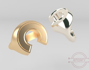 May include: Two gold and silver rings shaped like the letter C. The rings are both open on one side and closed on the other.