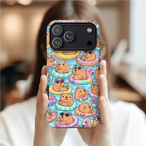 May include: A phone case with a repeating pattern of cartoon bears in sunglasses and inner tubes, floating in a pool. The bears are holding drinks. The case has a black camera module.