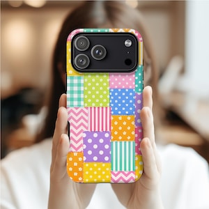 May include: A colorful patchwork phone case with a variety of patterns, including polka dots, stripes, and floral designs. The case features a mix of bright colors like pink, yellow, green, and blue, creating a vibrant and eye-catching accessory.