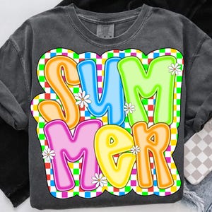May include: A charcoal gray t-shirt with a colorful "SUMMER" graphic. The letters are outlined in white and set against a checkered background of red, green, blue, and yellow squares.  White daisies are scattered throughout the design.