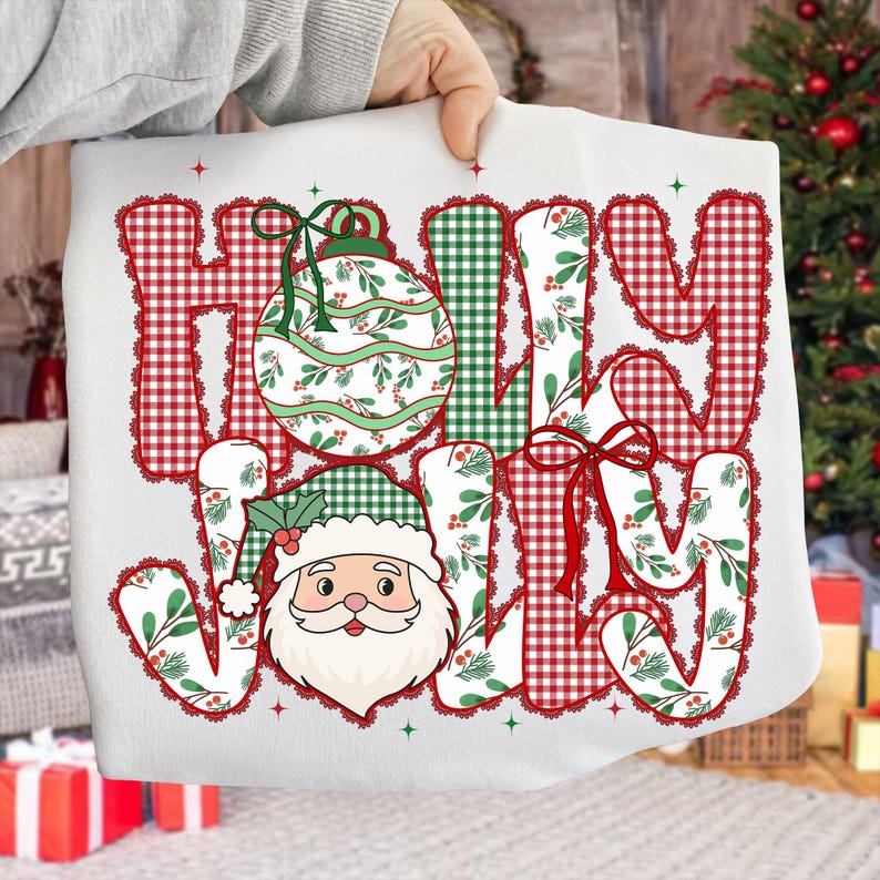 May include: A white Christmas-themed sweatshirt with the words "HOLY JOLLY" in a mix of red gingham, green gingham, and floral patterns. A Santa Claus face and a Christmas ornament are also featured.