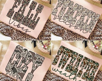May include: Four light pink sweatshirts with fall-themed text. The sweatshirts feature the phrases "Fall Vibes", "Pumpkin Season", "Cozy Season", and "Winter Weather" in a camouflage-style font. The background includes a leopard print pattern.