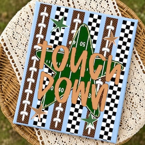 May include: A rectangular canvas print featuring a central green star shaped like a football field with yard lines and numbers. The background has vertical stripes of brown football laces, black and white checkers, and light blue. Text reads TOUCH DOWN.