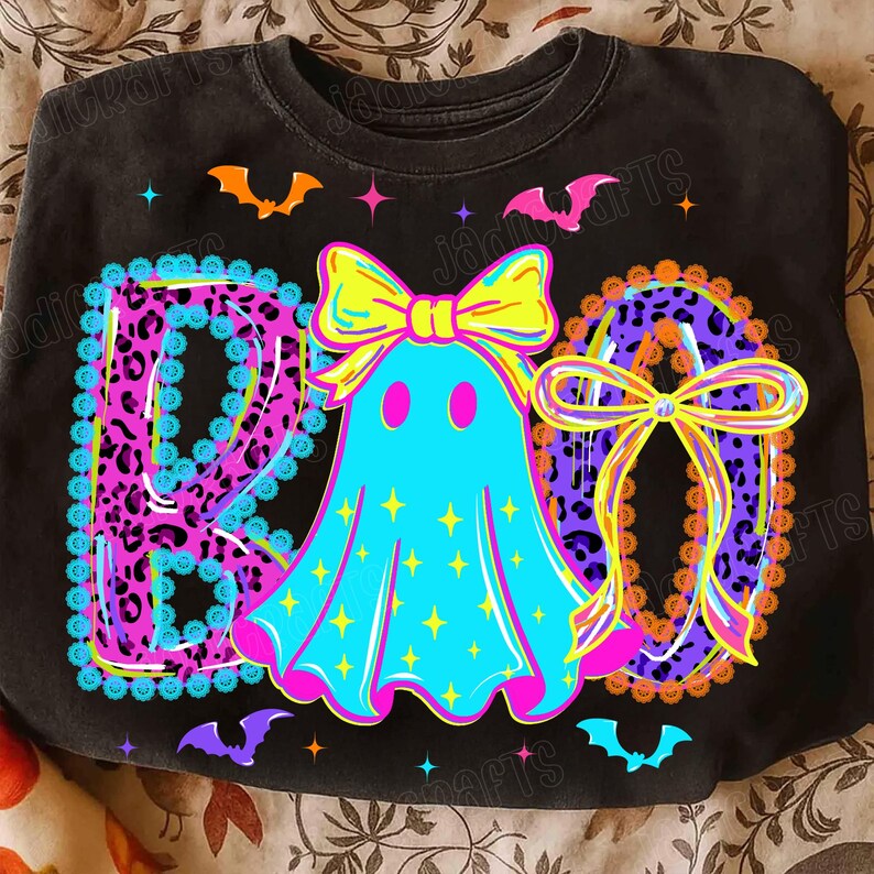 Peut inclure: Sweat-shirt noir avec un motif d'Halloween color&eacute;. Le mot "BOO" est &eacute;crit avec un motif l&eacute;opard. Un fant&ocirc;me turquoise avec un n&oelig;ud jaune est au centre. Des chauves-souris et des &eacute;toiles sont dispers&eacute;es autour du motif.