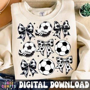 May include: Cream-coloured sweatshirt with a soccer theme. The design includes soccer balls, soccer cleats, and bows with soccer ball patterns. The words "DIGITAL DOWNLOAD" are at the bottom. The sweatshirt is a digital download.