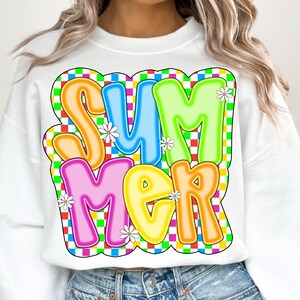 May include: White sweatshirt with a colorful "SUMMER" graphic in a checkered pattern. The letters are outlined in black and have a 3D effect.