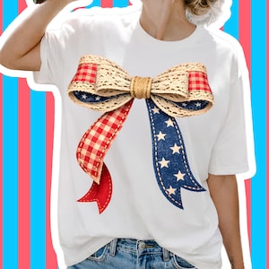 Op de afbeelding: Wit T-shirt met een groot strikdesign. De strik heeft een jute midden, rood-wit geblokte ruit en blauwe stof met witte sterren. De linten zijn rood en blauw, wat een patriottisch thema creëert.
