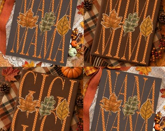 May include: A dark brown rectangular sign featuring the text MAMA, MIMI, GIGI, or NANA in white polka-dot lettering. Each sign displays three autumn leaves in orange, green, and yellow plaid patterns positioned between the letters of the name.
