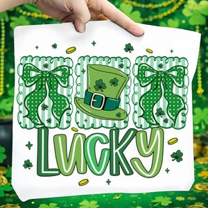 May include: White St. Patrick's Day design featuring a green leprechaun hat, green bows, shamrocks, and the word "LUCKY" in green and white. The design includes gold coins and decorative elements.