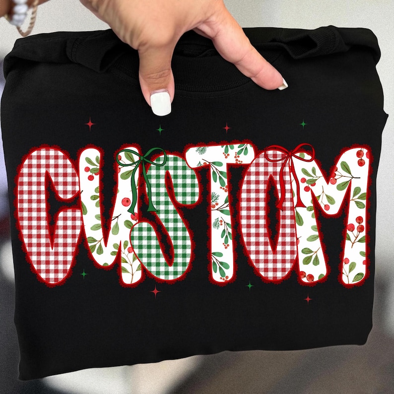 Pu&ograve; includere: Felpa nera con la scritta "CUSTOM" in grandi lettere festive. Le lettere sono riempite con motivi a quadri rossi e verdi, disegni floreali e accentate con fiocchi e bacche, perfetta per le festivit&agrave;.