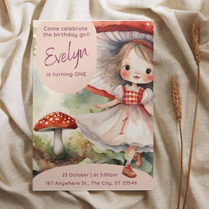 May include: A watercolor illustration of a girl wearing a red and white checkered dress and a mushroom hat. The text "Come celebrate the birthday girl! Evelyn is turning ONE" is at the top of the image. The text "23 October | at 3:00pm 187 Anywhere St., The City, ST 23546" is at the bottom of the image.