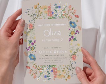 Könnte beinhalten: Eine florale Geburtstagseinladung für ein Mädchen namens Olivia, das zwei Jahre alt wird. Die Einladung hat einen hellbraunen Hintergrund mit einem floralen Rand und den Text "our little wildflower Olivia is turning 2 come celebrate! Olivia Wilson 23 FEB 2025 | AT 4 PM 23 BIRTHDAY STREET, THE CITY RSVP TO MEGHAN PHONE: 123-456-7890".