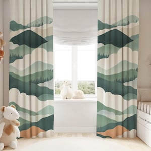 Könnte beinhalten: Ein Paar cremefarbene Vorhänge mit einem grünen und weißen Berglandschaft-Design. Die Vorhänge hängen in einem Kinderzimmer mit einem weißen Kinderbett und Stofftieren.