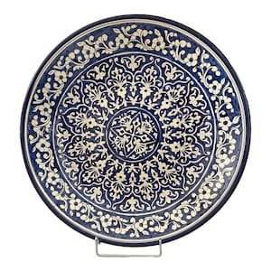 Può includere: Un grande piatto rotondo in ceramica blu con un motivo floreale bianco. Il piatto ha un bordo rialzato e una superficie liscia.