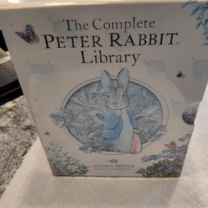 Peut inclure: Une tasse en céramique blanche avec une anse noire et le texte "But First, Coffee" en écriture manuscrite. La tasse est posée sur une surface blanche. Pour boissons chaudes.