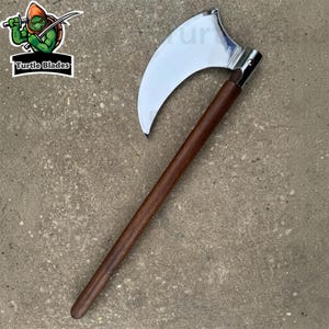 May include: A polearm featuring a large, curved, polished silver-colored metal blade attached to a long, straight, dark brown wooden handle. A logo in the top left corner depicts a green cartoon turtle with the text Turtle Blades.