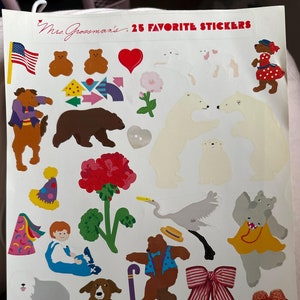 Puede incluir: Una hoja de pegatinas con diversas ilustraciones coloridas. Las pegatinas incluyen osos, perros, un león, un pingüino, un gato y otros diseños de animales y flores. El texto "Mrs. Grossman's 25 FAVORITE STICKERS" está impreso en la parte superior.