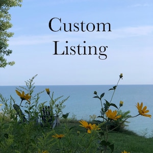 May include: A scenic outdoor view featuring a bright blue sky and a body of water. Yellow wildflowers bloom in the foreground, with the text "Custom Listing" in the center. The scene suggests a natural, serene setting.