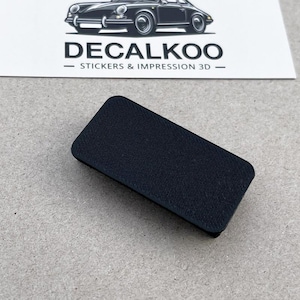 以下が含まれることがあります： 表面がテクスチャ加工された黒い長方形のボタン