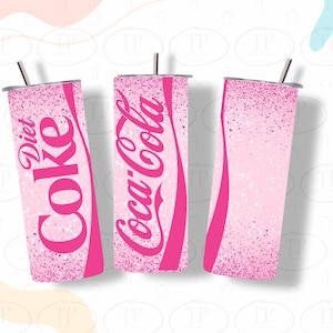 May include: Three pink glitter tumblers with a pink and white ombre effect. The tumblers have the words "Diet Coke", "Coca-Cola", and a blank space.
