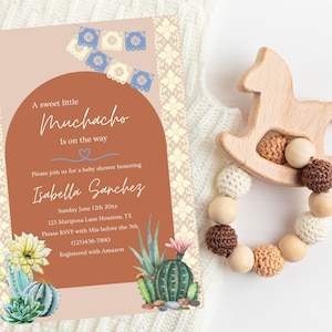 May include: A baby shower invitation with a terracotta background and a light pink arch. The invitation features a cactus illustration, a banner of blue and white paper flags, and the text "A sweet little Muchacho is on the way". The invitation also includes the name "Isabella Sanchez" and details for the shower.