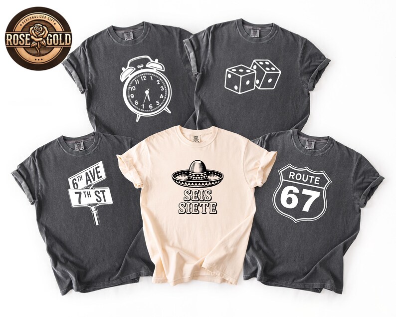 May include: Five t-shirts with various white graphics on them. The graphics include an alarm clock, dice, a street sign, a sombrero with the text "SEIS SIETE", and a Route 67 sign. The shirts are in shades of gray and beige.