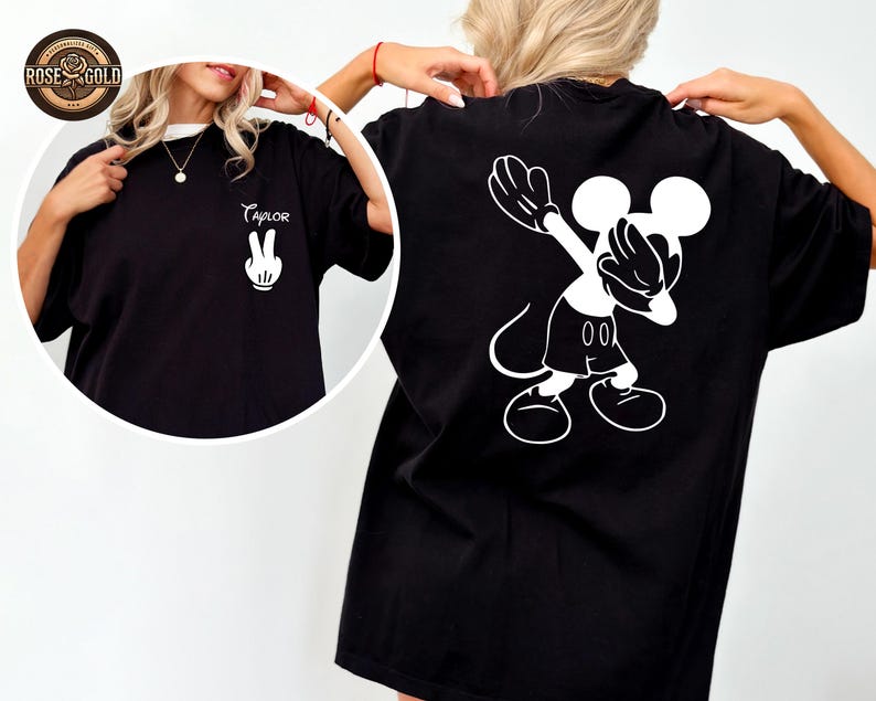 May include: Black t-shirt with a white Mickey Mouse graphic on the back, in a dabbing pose. The front of the shirt has a white peace sign hand and the name "Taylor" in cursive. The shirt has a white collar.