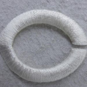 May include: White embroidered circle with a gap in the top, resembling a letter "C".