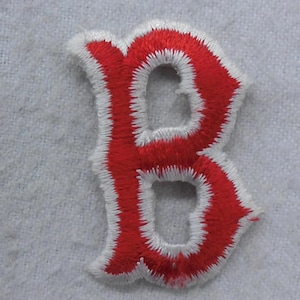 May include: Red felt letter B with white outline. The letter is embroidered and has a vintage style.
