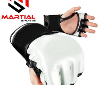 Op de afbeelding: Witte en zwarte MMA-handschoenen met de tekst "MARTIAL SPORTS" en een logo. De handschoenen hebben een gewatteerd wit slagvlak, zwarte polsbanden en vingeropeningen. Ontworpen voor training en competitie in mixed martial arts.