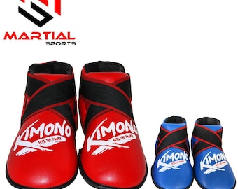 Op de afbeelding: Rode en zwarte voetbeschermers voor vechtsporten met het woord "KIMONO" in het wit. Twee kleinere blauwe en zwarte voetbeschermers zijn ook zichtbaar. Het logo "MARTIAL SPORTS" staat in de linkerbovenhoek.