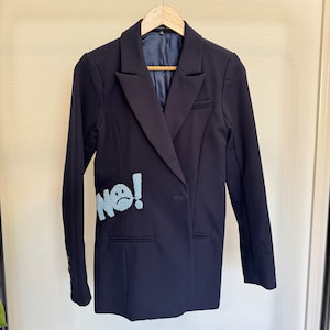 May include: A navy blue blazer with a light blue embroidered patch that says "NO!" with a sad face.
