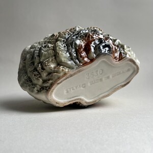 May include: A ceramic turkey figurine with a brown, white, and green glaze. The figurine is made in England and has the number 3530 printed on the bottom.