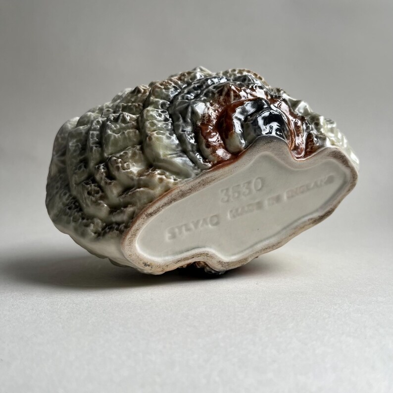 May include: A ceramic turkey figurine with a brown, white, and green glaze. The figurine is made in England and has the number 3530 printed on the bottom.