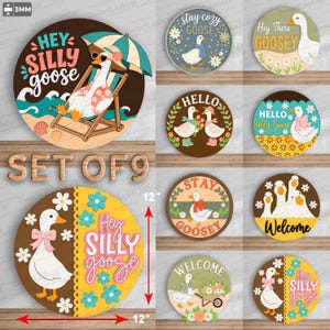 Pode incluir: Um conjunto de nove placas circulares de madeira com várias ilustrações de gansos e texto. Os designs incluem frases como Hey Silly Goose, Stay Cozy Goose, Hey There Goosey, Hello e Welcome. Uma seta vermelha indica 30,48 cm de diâmetro.