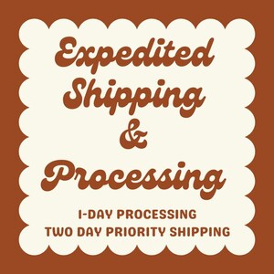 May include: A brown and cream-colored graphic with the words "Expedited Shipping & Processing" in a decorative font. The text "1-Day Processing" and "Two Day Priority Shipping" are also included.