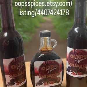 May include: Three bottles of Cassareep, a dark, viscous liquid, are displayed. The bottles vary in shape, with labels featuring the text "OOPS Spices Cassareep." The image includes the text "Cassareep available at oopsspices.etsy.com."