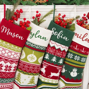 Puede incluir: Cuatro calcetines navideños de punto con patrones festivos en rojo, verde y blanco. Cada calcetín tiene un puño de color sólido bordado con los nombres Mason, Dylan, Sofia y Camila. Los calcetines están rellenos de ramas de bayas rojas.