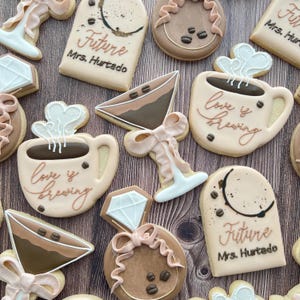 various sugar cookies including a coffee martini, elongated arch frame, and a coffee mug with steam hearts