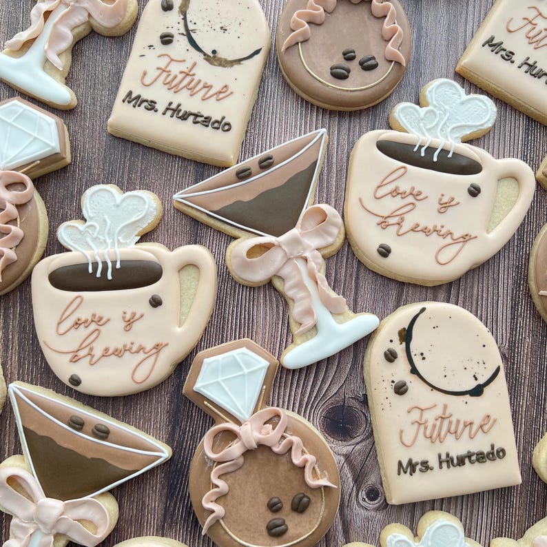 various sugar cookies including a coffee martini, elongated arch frame, and a coffee mug with steam hearts