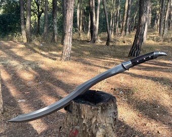 May include: A silver-colored sword with a black handle and a curved blade. The sword is resting on a tree stump in a forest setting.