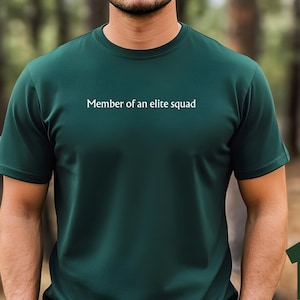 May include: A dark green t-shirt with the text "Member of an elite squad" printed on the front.