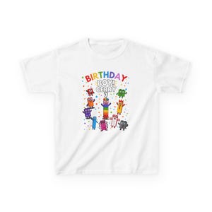 May include: A white short-sleeve t-shirt featuring a colourful graphic of Numberblocks characters. The text reads BIRTHDAY BOY! GERRY 7, surrounded by small multi-coloured stars and confetti shapes. The design is centred on the front of the shirt.