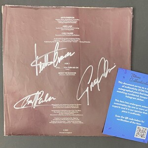 May include: A vintage vinyl record album cover with signatures and text. The cover is a faded brown color with white signatures and text. A blue Thorne Authentication card is in the lower right corner.
