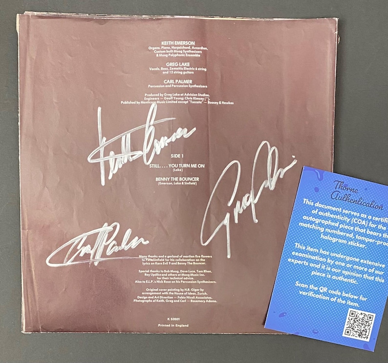 May include: A vintage vinyl record album cover with signatures and text. The cover is a faded brown color with white signatures and text. A blue Thorne Authentication card is in the lower right corner.