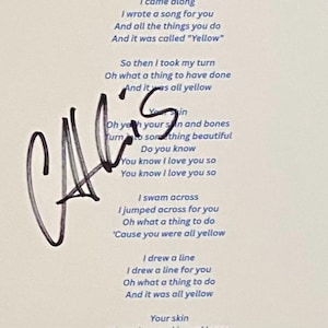 May include: A white print featuring song lyrics and a signature in black ink. The text includes the words "Yellow" and "I love you so." The signature appears to be "CA's".