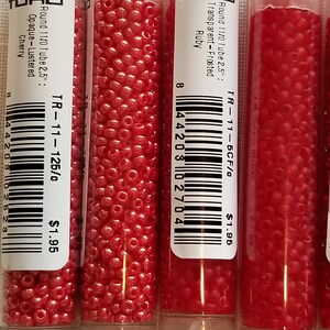 Pode incluir: Tr&ecirc;s tubos de contas de sementes vermelhas TOHO. Os tubos s&atilde;o etiquetados com o tamanho da conta, a cor e o acabamento. Os tubos s&atilde;o etiquetados "Round 11/0 Tube 2.5": Transparent-Frosted Ruby", "Round 11/0 Tube 2.5": Opaque-Lustered Cherry", e "Round 11/0 Tube 2.5": Transparent-Frosted Ruby". Cada tubo custa &euro; 1,95.
