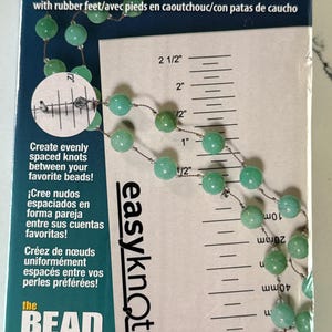 May include: An "easyknotter" tool with a ruler, designed for creating evenly spaced knots between beads. The tool features a ruler with inch measurements, and the text "Create evenly spaced knots between your favorite beads!"