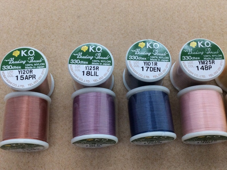 May include: Six spools of 330dtex nylon beading thread in various colours, including copper, purple, blue, and pink. Each spool has a label with the brand name "K.O. Beading Thread", the lot number, and the colour code.