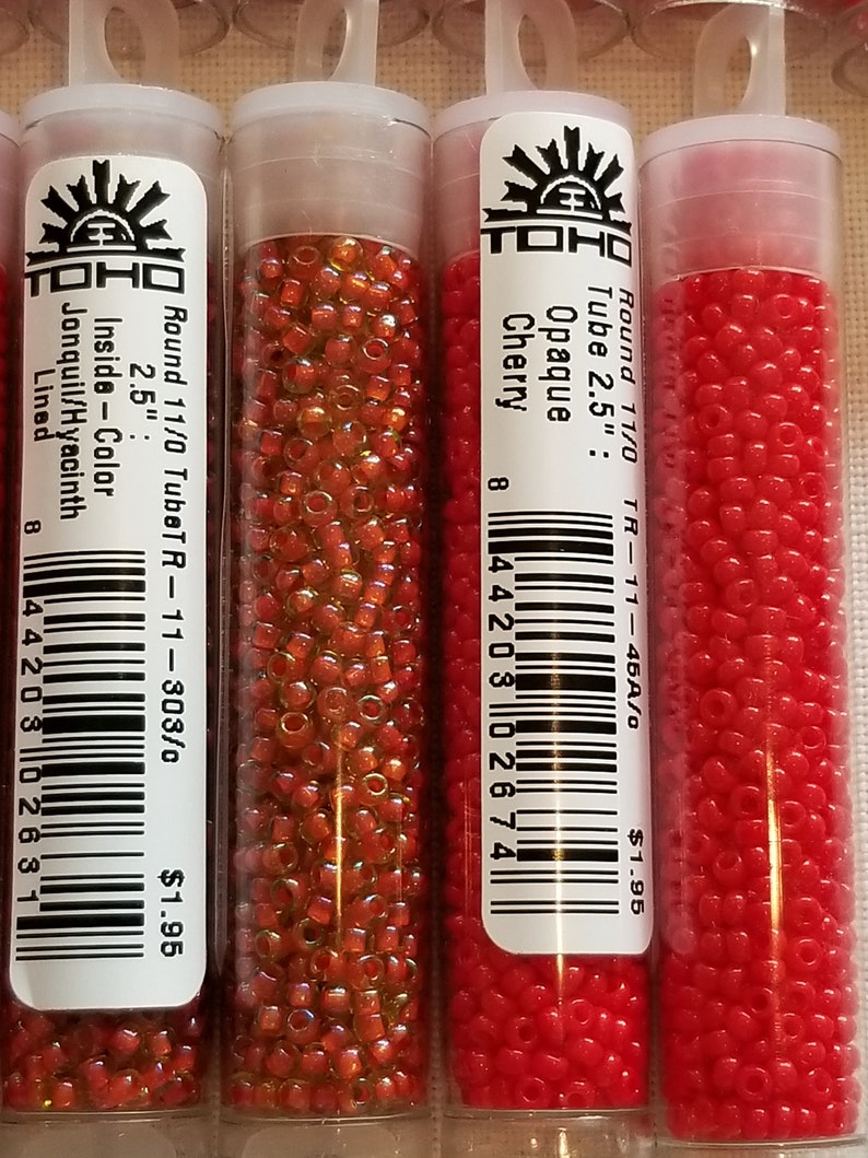 Pode incluir: Tr&ecirc;s tubos de contas de semente TOHO. O tubo &agrave; esquerda cont&eacute;m contas de tamanho 11/0 na cor Jonquil/Jacinto. O tubo do meio cont&eacute;m contas de tamanho 11/0 na cor Cereja Opaca. O tubo &agrave; direita cont&eacute;m contas de tamanho 11/0 na cor vermelha. Cada tubo mede 6,35 cm de comprimento.